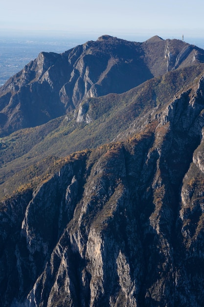 Bellissimo paesaggio della catena montuosa nebbiosa delle Alpi italiane durante la serata lombarda