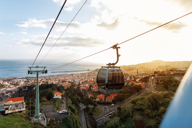 Bellissimo paesaggio della città di Funchal con funivie tetti arancioni e l'oceano al tramonto Viaggiando sull'isola di Madeira