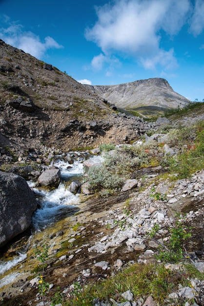 Bellissimo paesaggio delle montagne Khibiny con rocce e un ruscello di montagna in una giornata di sole. Penisola di Kola, Russia