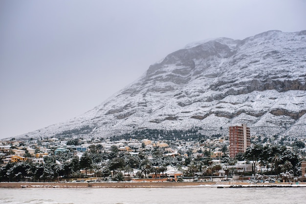 Bellissimo paesaggio di mare e montagna innevata