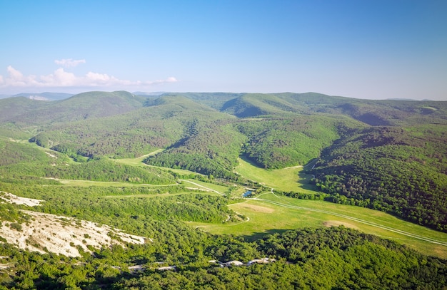 Bellissimo paesaggio di montagna con cielo azzurro e campi verdi