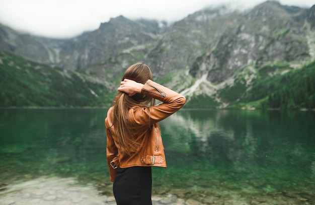 Bellissimo paesaggio di montagna e lago con la donna