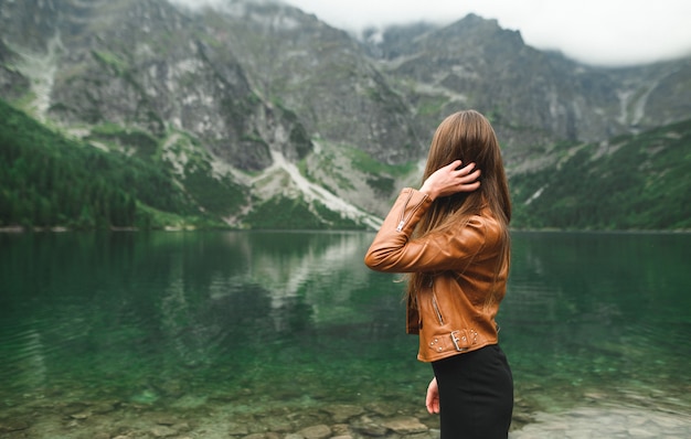 Bellissimo paesaggio di montagna e lago con la donna