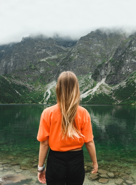 Bellissimo paesaggio di montagna e lago con la donna