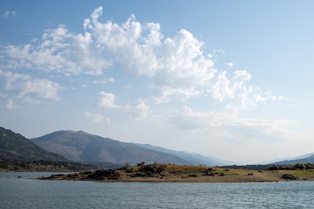 Bellissimo paesaggio di un lago con uno sfondo di montagne e nuvole