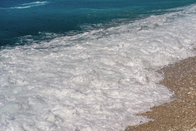 Bellissimo paesaggio di una spuma del mare con un'onda di schiuma per uno sfondo naturale o per lo sfondo