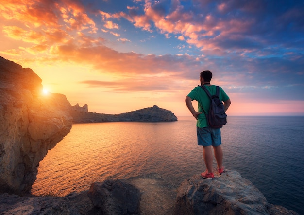 Bellissimo paesaggio estivo con uomo in piedi con zaino