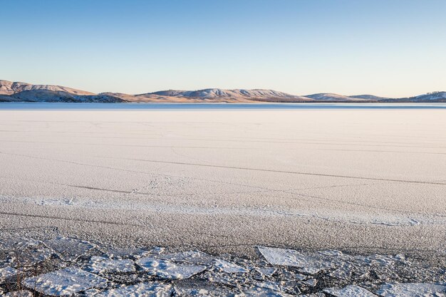 Bellissimo paesaggio invernale con ghiaccio e neve sul lago