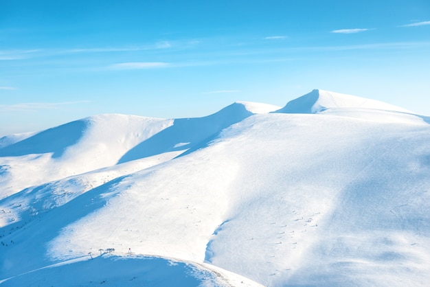 Bellissimo paesaggio invernale con montagne di neve sotto il cielo blu blue