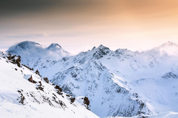 Bellissimo paesaggio invernale con montagne innevate al tramonto