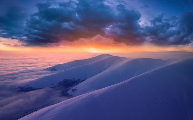 Bellissimo paesaggio, mare di nebbia, cime innevate e cielo nuvoloso e vista sulle montagne.