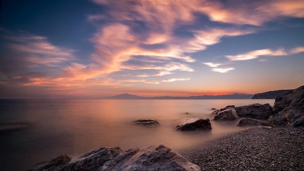 Bellissimo paesaggio marino al tramonto con formazioni rocciose nell'acqua