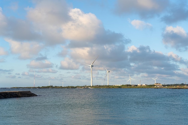Bellissimo paesaggio marino con nuvole fantastiche con vista su una turbina eolica