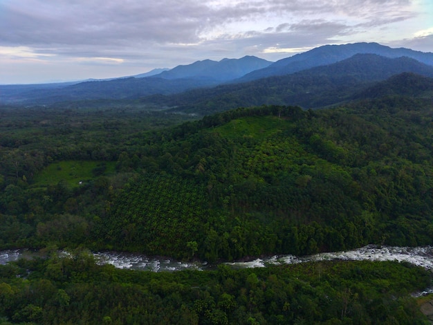 Bellissimo paesaggio mattutino indonesiano Foto aerea del fiume tra montagne e foreste
