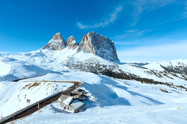 Bellissimo paesaggio montano invernale con parcheggio e strada (Passo Sella, Italia).