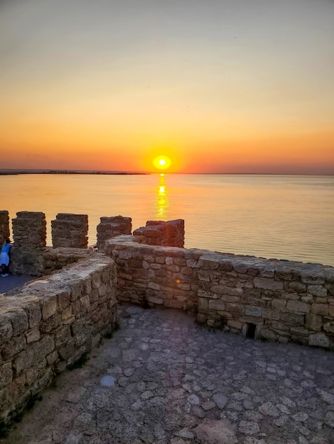 Bellissimo paesaggio naturale vista mare la sera al tramonto muro di pietra antica fortezza medievale