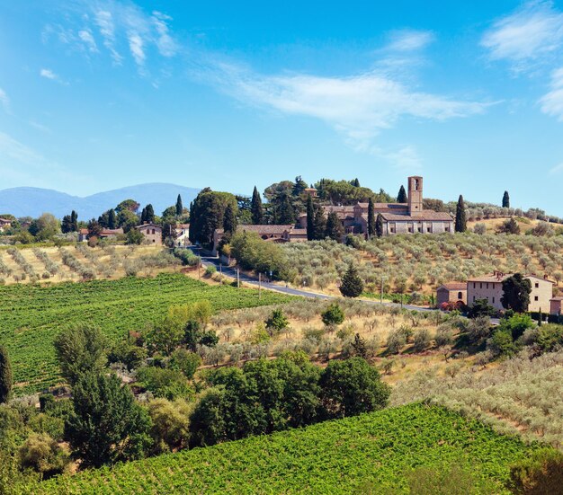 Bellissimo paesaggio rurale estivo della Toscana dalle mura della città di San Gimignano Tipico della regione italiana Toscana case agricole colline campi di grano olive giardini vigneti cipressi passa