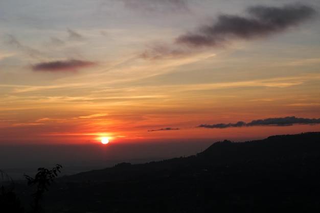 Bellissimo paesaggio silhouette alba sopra la collina