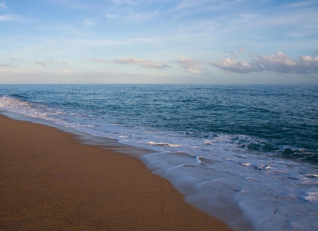 Bellissimo paesaggio sulla costa della spiaggia e onde del mare sullo sfondo del cielo blu