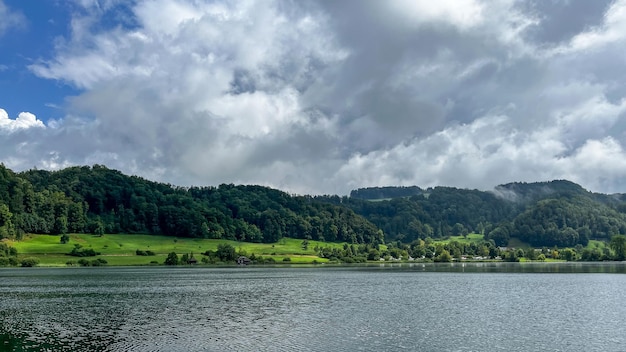 Bellissimo paesaggio svizzero Vista di un piccolo lago con una foresta verde sullo sfondo