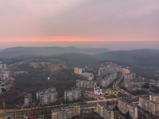 Bellissimo paesaggio urbano con l'alba. il sole rosso sorge sopra le montagne