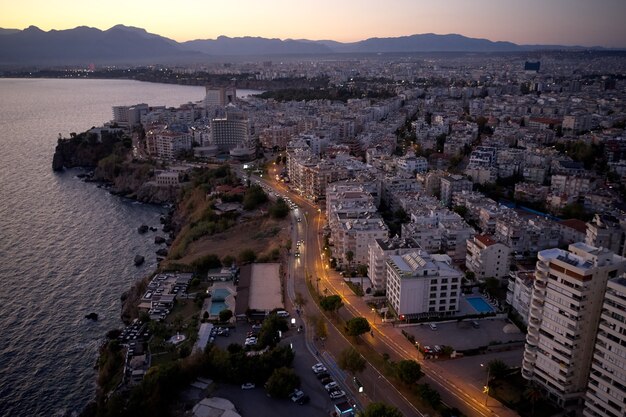 Bellissimo paesaggio urbano e mare al tramonto. Edifici della città vicino alla riva del mare. Vista dall'alto dal drone.