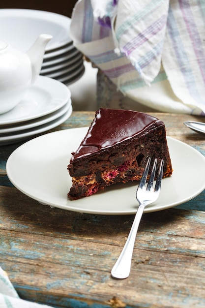 Bellissimo pezzo gustoso di torta al cioccolato sul piatto su fondo di legno