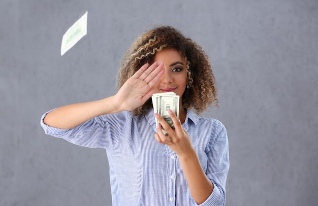 Bellissimo ritratto di donna nera Scattering soldi note dollari in capelli ricci stile voti di moda con serrature bianche vista dell'occhio della fotocamera