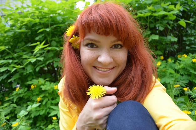 Bellissimo ritratto di una giovane donna dai capelli rossi con fiori tra i capelli