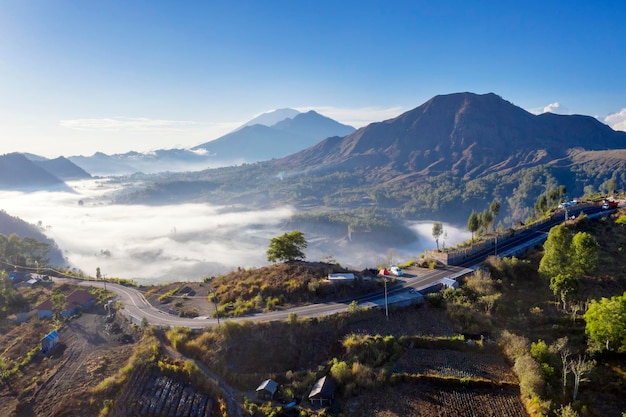 Bellissimo scenario aereo del nebbioso villaggio di Pinggan con il monte Batur al mattino a Bali Indonesia