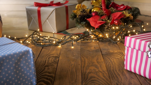 Bellissimo sfondo di Natale con luci, regali e albero di Natale su flory in legno. Copia spazio per il tuo testo o design