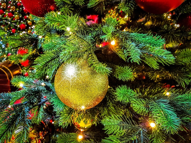 Bellissimo sfondo di Natale palline lucide su uno sfondo di luci sfocate su un albero di Natale con effetto bokeh