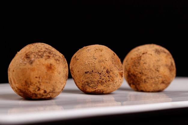 Bellissimo tartufo di caramelle su un piatto bianco su sfondo nero