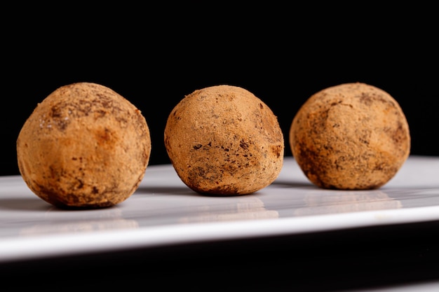 Bellissimo tartufo di caramelle su un piatto bianco su sfondo nero