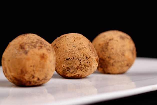 Bellissimo tartufo di caramelle su un piatto bianco su sfondo nero