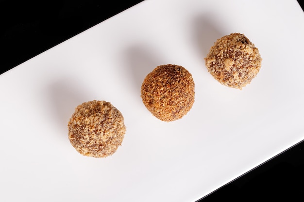 Bellissimo tartufo di caramelle su un piatto bianco su sfondo nero