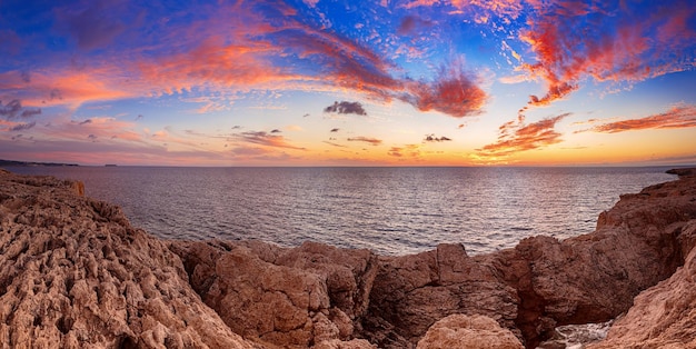 Bellissimo tramonto colorato sul mare con nuvole drammatiche e cielo colorato. Fondo di viaggio naturale all'aperto del mondo di bellezza. Vista panoramica