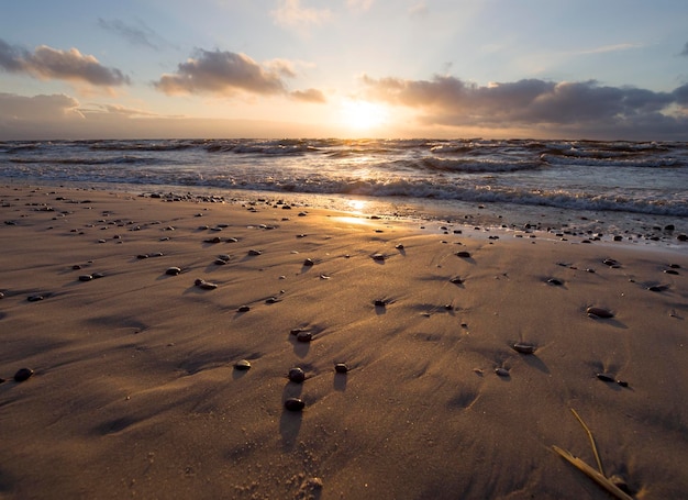 Bellissimo tramonto invernale sulla spiaggia sabbiosa del Mar Baltico in Lituania Klaipeda