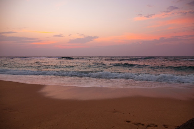 Bellissimo tramonto rosa dall'oceano in tempesta