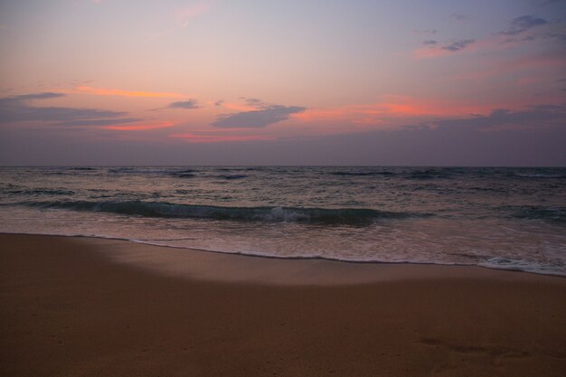 Bellissimo tramonto rosa dall'oceano in tempesta