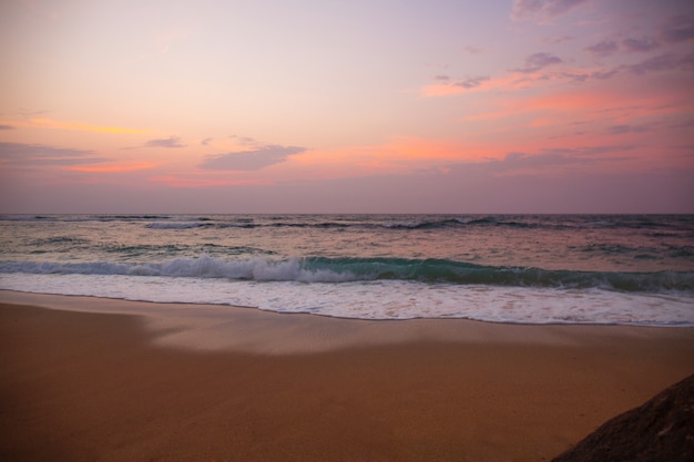 Bellissimo tramonto rosa dall'oceano in tempesta