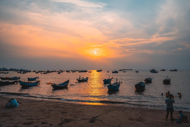 Bellissimo tramonto Tropical Seascape con una barca sulla spiaggia sabbiosa a nuvoloso