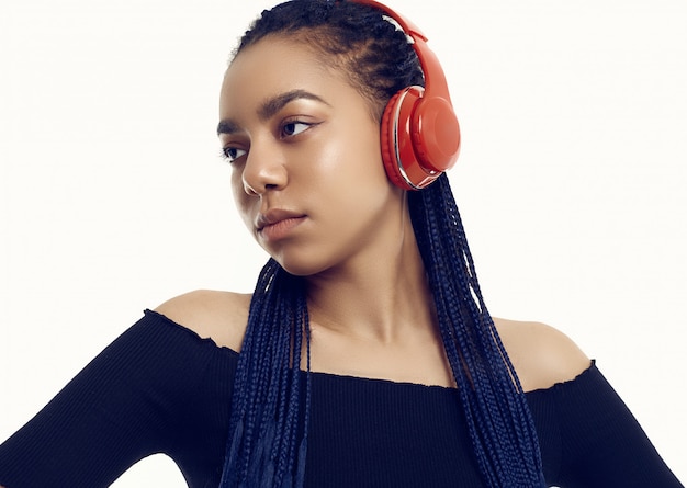 Bello adolescente africano del brunette con musica d'ascolto dei dreadlocks