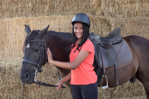 Bello adolescente con il suo cavallo che impara cavalcare