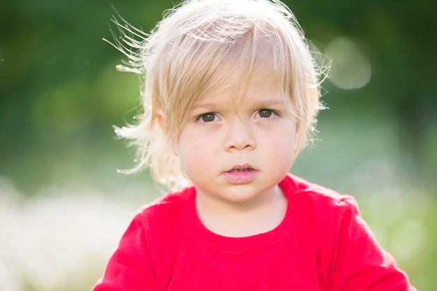 Bello bambino biondo di due anni Il volto del bambino si chiuda