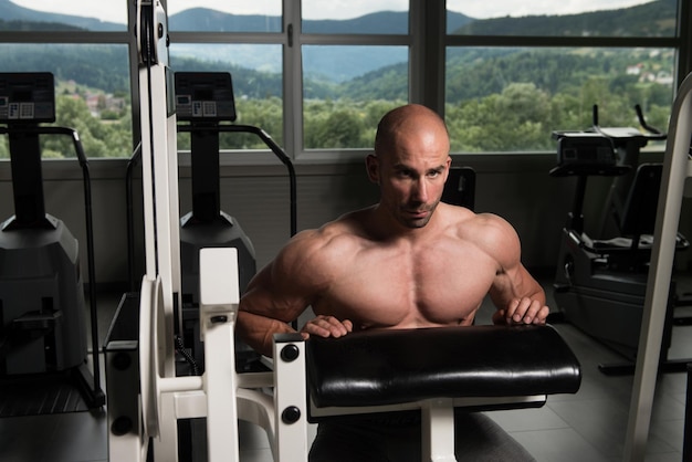 Bello bello e giovane attraente con il corpo muscoloso che si rilassa in palestra