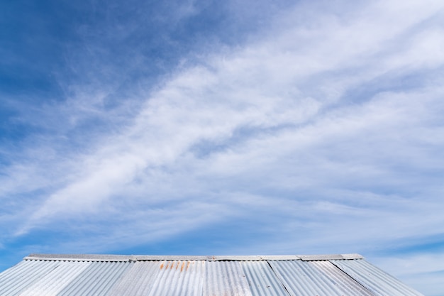 Bello cielo sopra il tetto dello zinco nel fondo dello spazio di giorno soleggiato per testo.