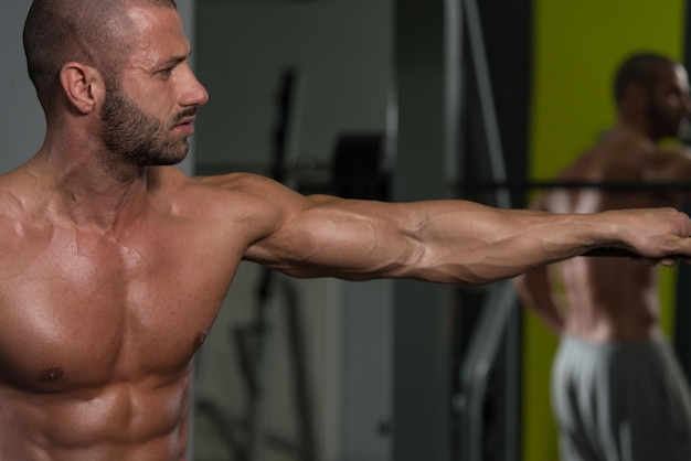 Bello e attraente giovane con corpo muscoloso rilassante in palestra