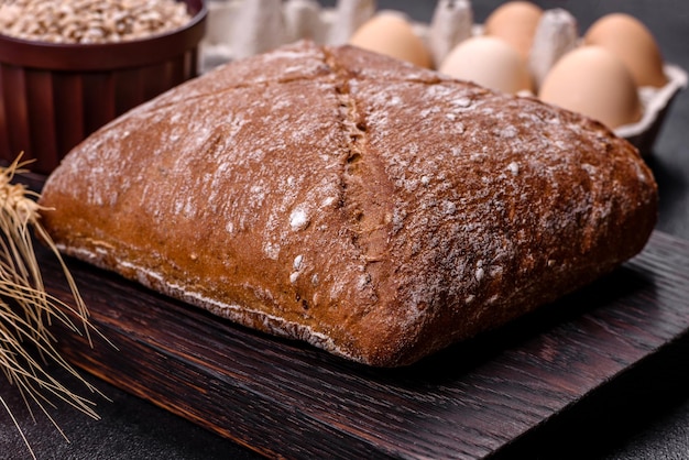 Bello e gustoso pane nero a forma quadrata su uno sfondo di cemento scuro