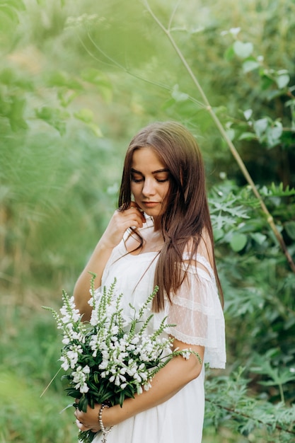 Bello giovane mazzo della tenuta della donna del brunette dei wildflowers di estate